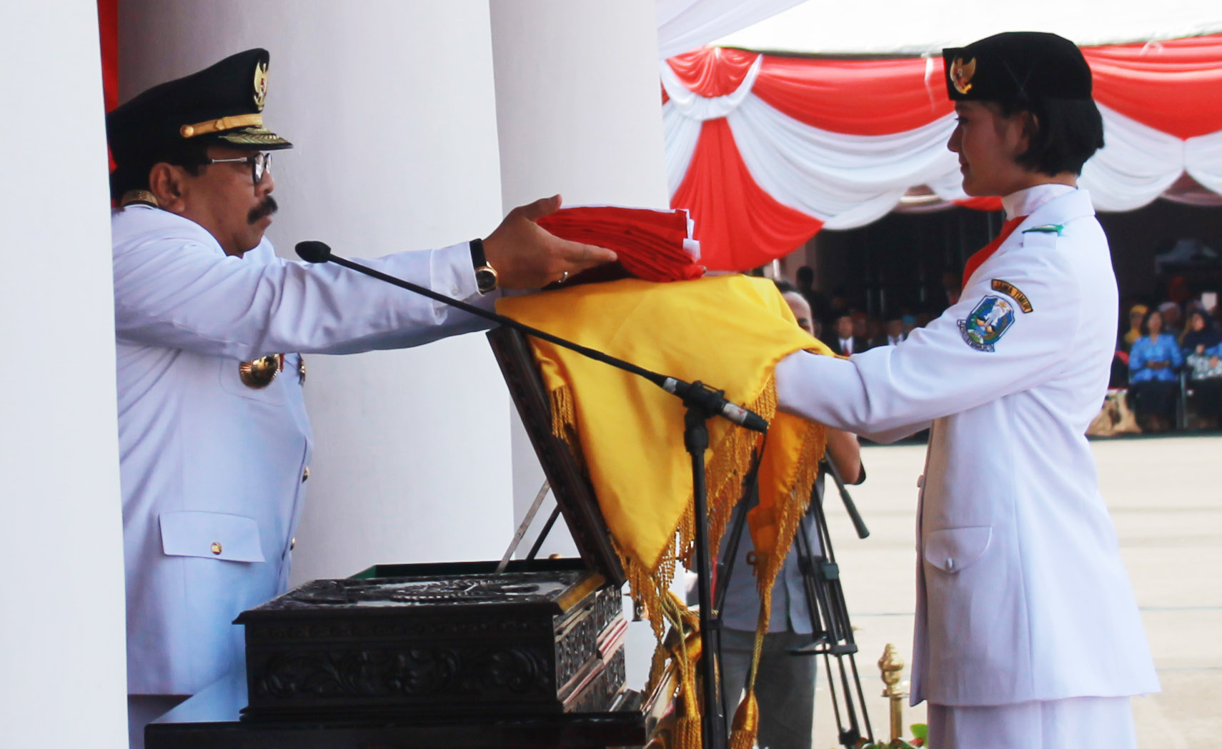 Gubernur Soekarwo menyerahkan bendera merah putih kepada paskibra di upacara peringatan HUT ke-71 Kemerdekaan RI di Gedung Negara Grahadi, Surabaya, Rabu (17/8).