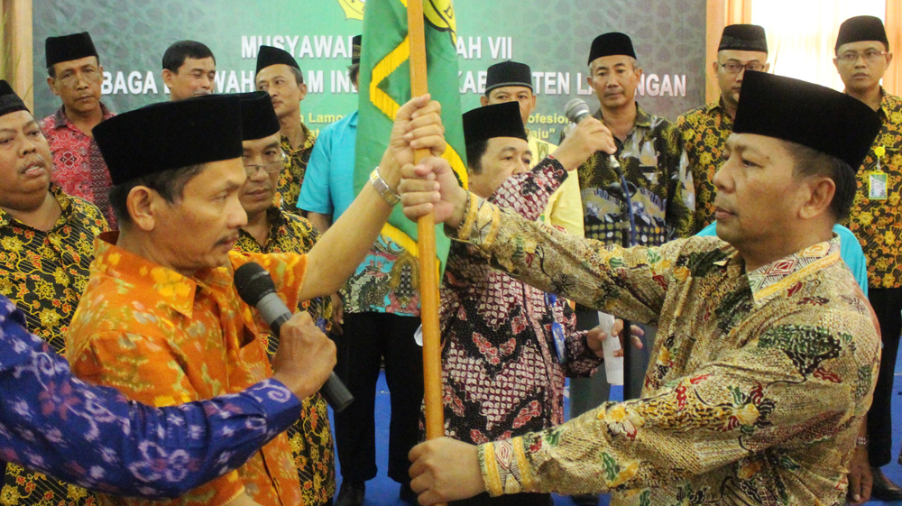 Ketua DPW LDII Provinsi Jawa Timur Drs. Ec. H. M. Amien Adhy (kanan) menyerahkan panji LDII kepada Ketua LDII Lamongan terpilih Ir. H. Bayu Widodo di Grand Mahkota Hotel Lamongan, Minggu (27/11).