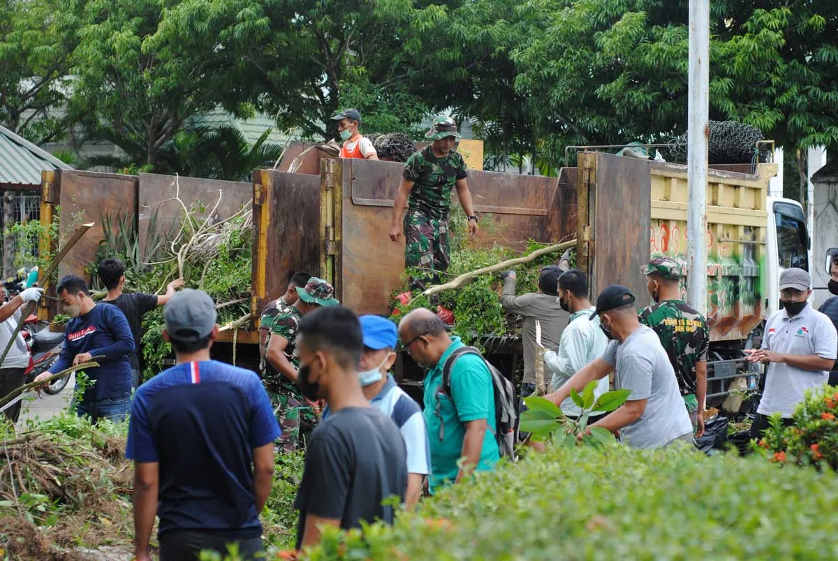 Seorang prajurit TNI di atas truk mengangkut ranting pohon saat bersih-bersih di kawasan Cagar Budaya Monpera, Balikpapan. 5 Februari 2022.