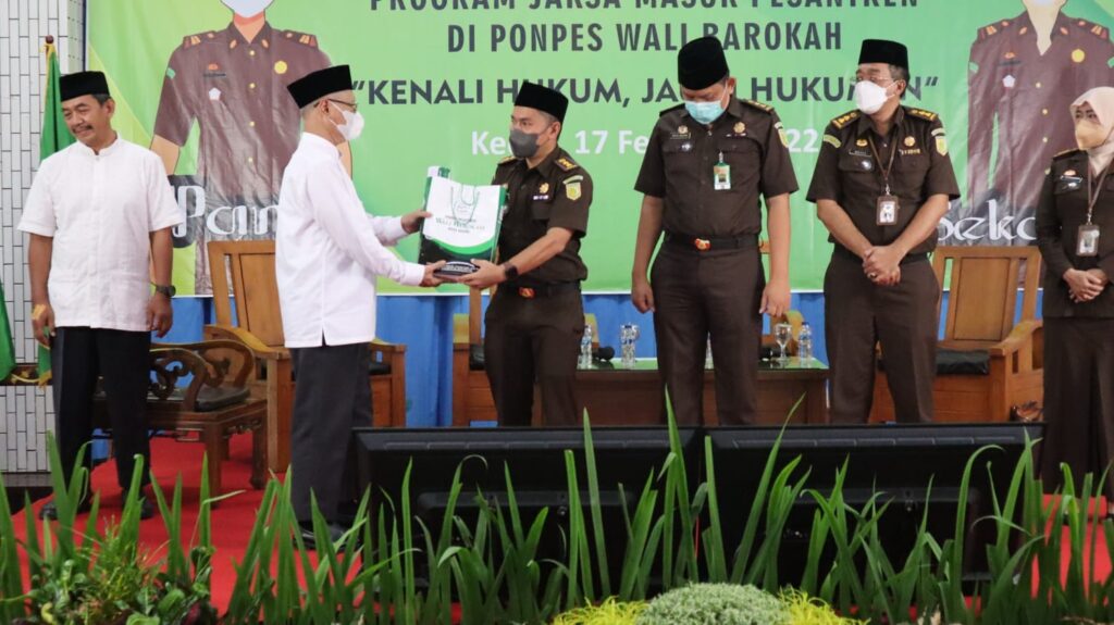 Pimpinan Ponpes Wali Barokah, KH Sunarto (kiri) menyerahkan cinderamata pada Kepala Kejari Kota Kediri. Dok. Lines Kediri.