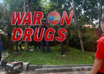 Seorang pegawai BNN Kota Surabaya mengawasi pekerjaan huruf timbul War on Drugs di Kawasan Taman Pelangi, Surabaya, 24 Maret 2022. Dok: Lines Jatim.