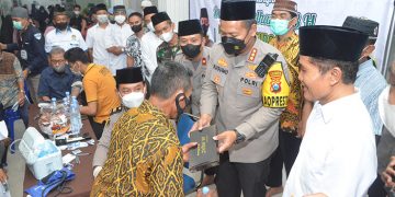 Kapolresta Sidoarjo Kombespol Kusumo Wahyu Bintoro bagikan sarung pada warga yang melakukan vaksin booster, 14 April 2022. Dok: Kontributor KIM Sidoarjo.