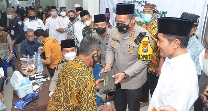 Kapolresta Sidoarjo Kombespol Kusumo Wahyu Bintoro bagikan sarung pada warga yang melakukan vaksin booster, 14 April 2022. Dok: Kontributor KIM Sidoarjo.