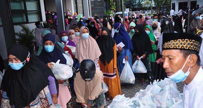 Warga mengantri menerima sepaket sembako dan santunan di halaman Gedung DPD LDII Gresik. Dok: Kontributor KIM Gresik.