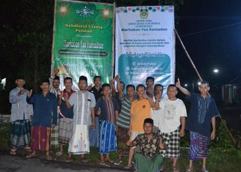 Pengurus Ranting Nahdlatul Ulama (NU) dan PC LDII Kecamatan Badas bergotong royong memasang banner (spanduk) Ramadan, 2 April 2022. Dok: Kontributor KIM Kabupaten Kediri.