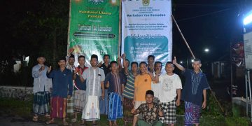 Pengurus Ranting Nahdlatul Ulama (NU) dan PC LDII Kecamatan Badas bergotong royong memasang banner (spanduk) Ramadan, 2 April 2022. Dok: Kontributor KIM Kabupaten Kediri.