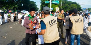 Pemuda LDII Jawa Timur membagikan 12.000 botol air mineral kepada peserta Resepsi Puncak Satu Abad Nahdlatul Ulama (NU), Selasa (7/2). Dok: LINES.