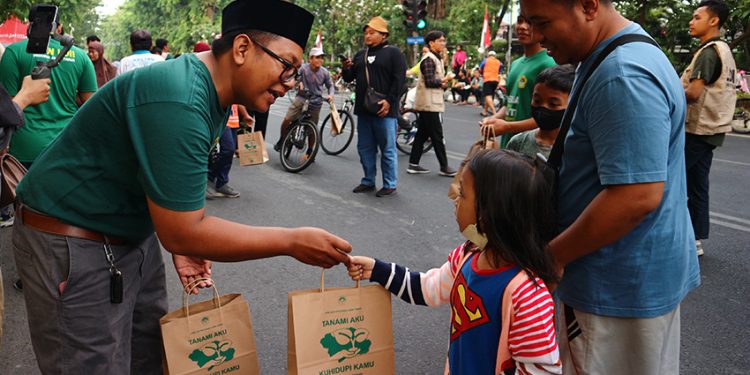 Relawan LDII Jatim membagikan bibit tanaman kepada warga Surabaya di acara Car Free Day (CFD) di Taman Bungkul Surabaya, Minggu (27/8). Dok: LINES.