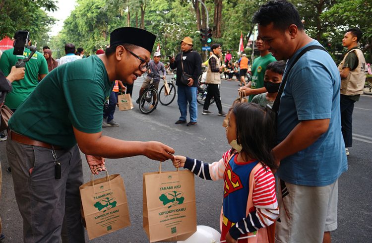 Relawan LDII Jatim membagikan bibit tanaman kepada warga Surabaya di acara Car Free Day (CFD) di Taman Bungkul Surabaya, Minggu (27/8). Dok: LINES.