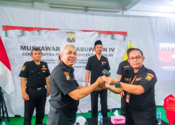 Sekretaris Pengprov Senkom Mitra Polri Jawa Timur Wahjoe Soetiono (kiri) menyerahkan palu sidang sebagai dimulainya sidang rapat pleno. Dok: LINES.