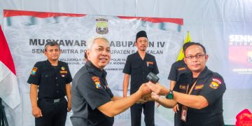 Sekretaris Pengprov Senkom Mitra Polri Jawa Timur Wahjoe Soetiono (kiri) menyerahkan palu sidang sebagai dimulainya sidang rapat pleno. Dok: LINES.