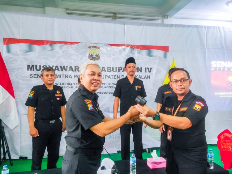 Sekretaris Pengprov Senkom Mitra Polri Jawa Timur Wahjoe Soetiono (kiri) menyerahkan palu sidang sebagai dimulainya sidang rapat pleno. Dok: LINES.