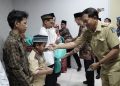 Lurah Gunung Anyar, Surabaya, Julius Gunandar bersama pengurus IPSM dan LDII, bagikan santunan kepada anak yatim, di Kantor Kecamatan Gunung Anyar, Selasa (2/4). Dok: LINES.