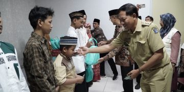 Lurah Gunung Anyar, Surabaya, Julius Gunandar bersama pengurus IPSM dan LDII, bagikan santunan kepada anak yatim, di Kantor Kecamatan Gunung Anyar, Selasa (2/4). Dok: LINES.