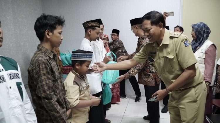 Lurah Gunung Anyar, Surabaya, Julius Gunandar bersama pengurus IPSM dan LDII, bagikan santunan kepada anak yatim, di Kantor Kecamatan Gunung Anyar, Selasa (2/4). Dok: LINES.
