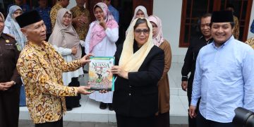 Ketua Ponpes Wali Barokah KH Sunarto (kiri) menyerahkan majalah Nuansa pada PJ Wali Kota Kediri Zanariah saat berkunjung ke Ponpes Wali Barokah, Rabu (17/4). Dok: LINES.