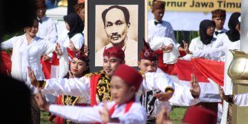 Para pelajar menampilkan Tarian Remo sambil membawa foto tokoh pendiri Budi Utomo Dr. Soetomo pada peringatan Hari Kebangkitan Nasional (Harkitnas) di Halaman Gedung Negara Grahadi Surabaya, Senin (20/5). Dok: LINES.