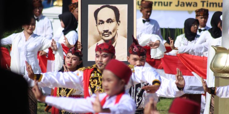 Para pelajar menampilkan Tarian Remo sambil membawa foto tokoh pendiri Budi Utomo Dr. Soetomo pada peringatan Hari Kebangkitan Nasional (Harkitnas) di Halaman Gedung Negara Grahadi Surabaya, Senin (20/5). Dok: LINES.