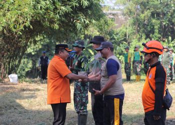Bupati Jember Hendy Siswanto menyerahkan bibit pohon pada relawan, sebelum melakukan aksi peduli lingkungan bersih-bersih sungai Bedadung, Kecamatan Kaliwates, pada Sabtu (20/7). Dok: LINES.
